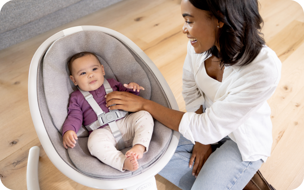 Mom interacting with baby girl buckled into Sway ’n Grow 3-in-1 silent swing