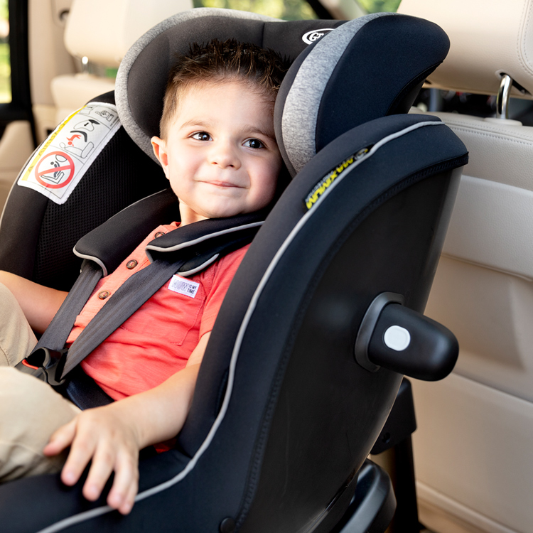 Little boy sitting in Graco Ascent car seat that has True Shield Safety Surround