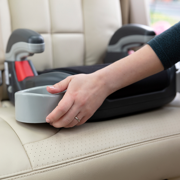 Person opening the retractable cupholder on Graco's Booster Basic car seat