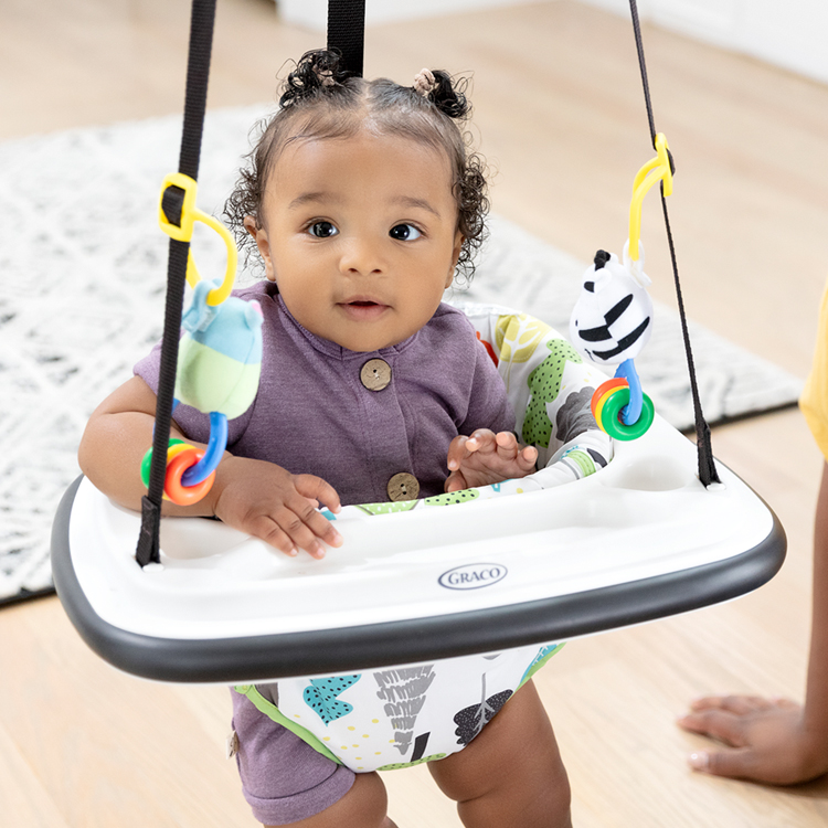 Little girl playing in Graco Bumper Jumper doorway jumper