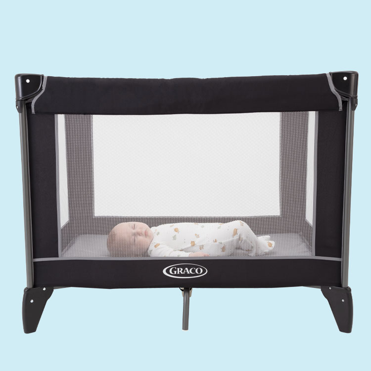 Baby sleeping seen through the mesh of Graco Compact travel cot