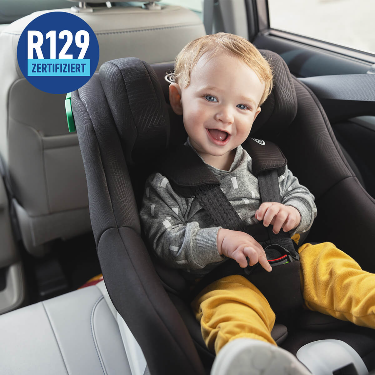 Glückliches Baby im Graco Extend LX R129 im Auto mit R129-zertifiziertem Logo.

