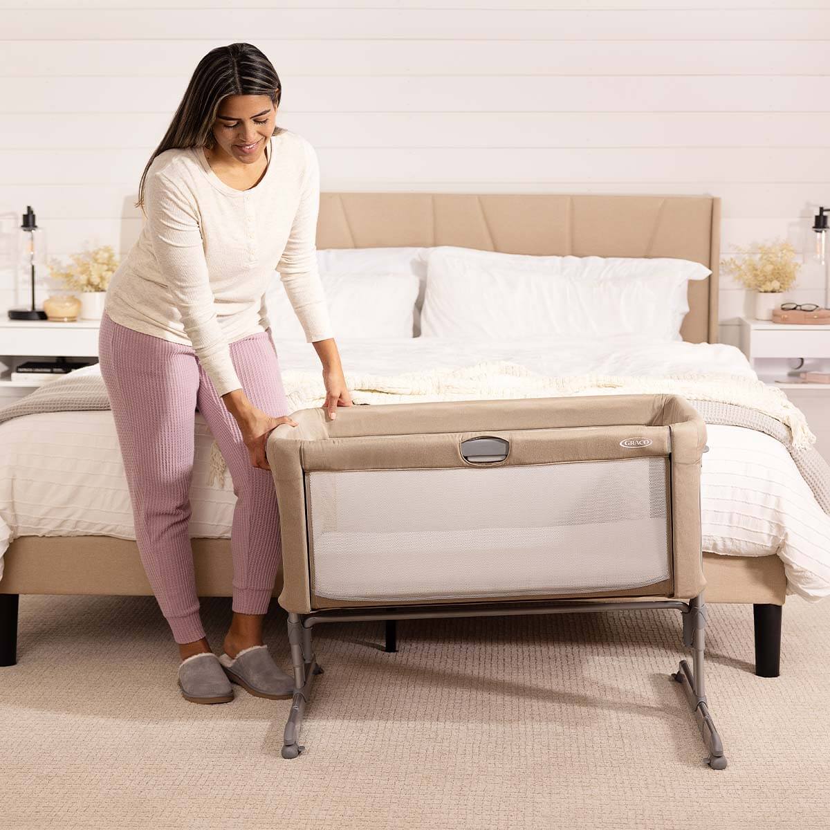 Graco Sweet2Sleep inclinata con il bambino nel prodotto e la mamma che controlla il bambino.