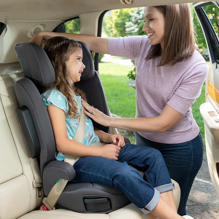 Mother buckling a little girl safely into Graco EverSure car seat