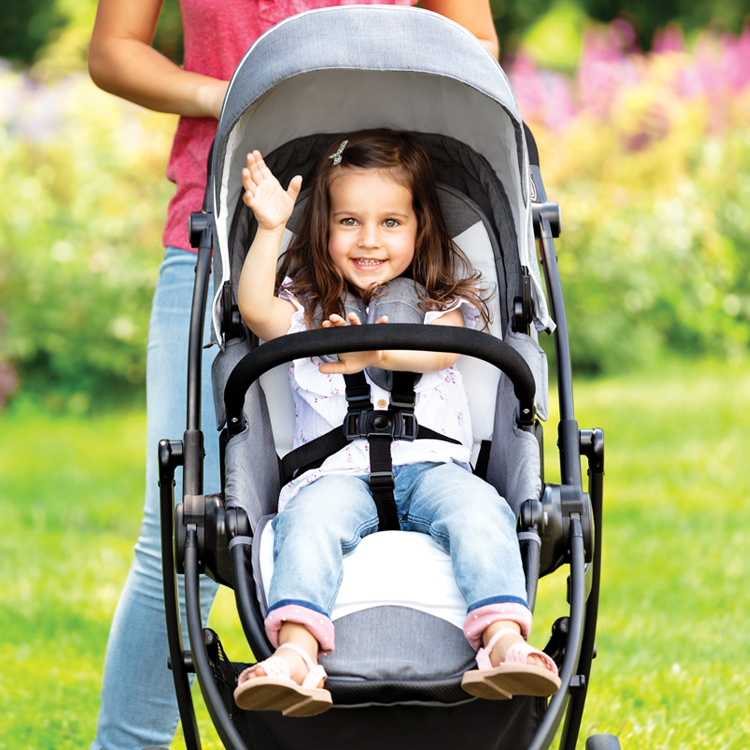 Little girl riding in Graco® Evo® XT while mum pushes her