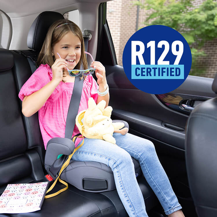Little girl sitting in Graco Booster Max R129 ISOFIX backless booster while putting on sunglasses and smiling with R129 certified logo
