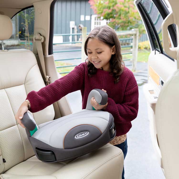 Petite fille plaçant le siège-auto Graco EverSure Lite dans la voiture