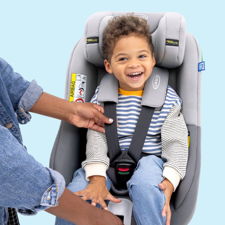 Woman's hand pulling up the no-rethread harness of the Graco Extend LX R129 car seat