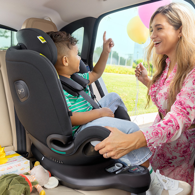 Mamma e bambino che ridono e interagiscono mentre la mamma ruota verso di sè il seggiolino Graco Turn2Me Grow i-Size R129 con il bambino.
