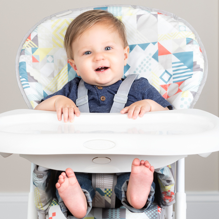 Baby sitzt im Hochstuhl Graco Snack N' Stow