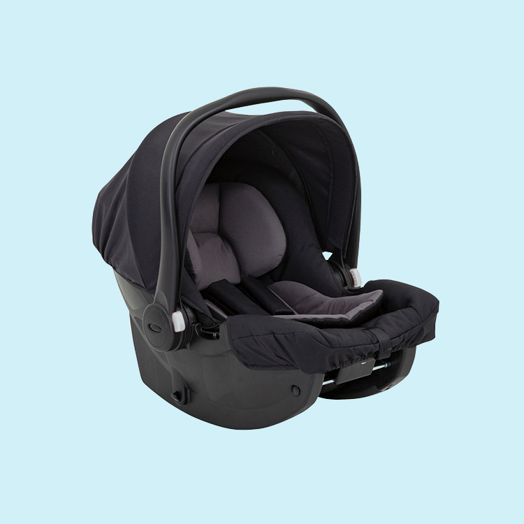 Bebé feliz en la silla de coche Graco SnugEssentials i-Size sobre fondo azul.