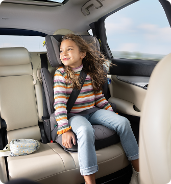 Young girl laughing while buckled into Energi i-Size R129  2-in-1 harness booster car seat.