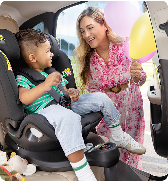 Young girl laughing while buckled into Energi i-Size R129  2-in-1 harness booster car seat.
