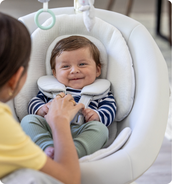 Little girl smiling while buckled into SnackEase quick-folding highchair.